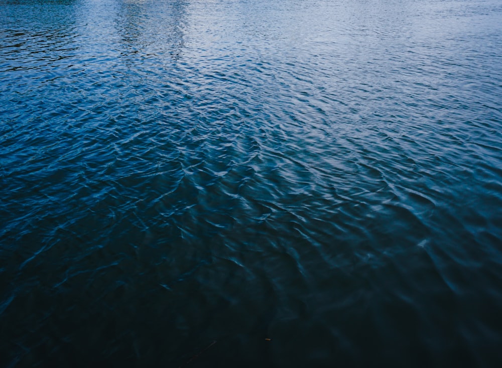 a large body of water with a boat in the distance