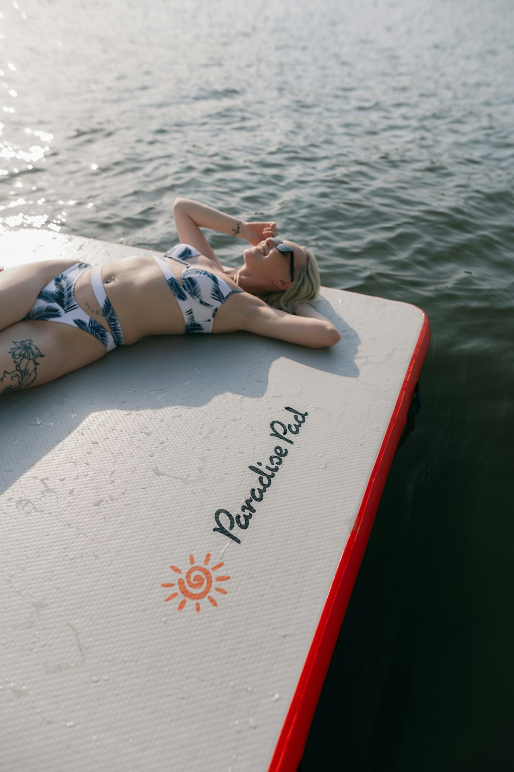 Une femme allongée sur une planche de surf dans l’eau