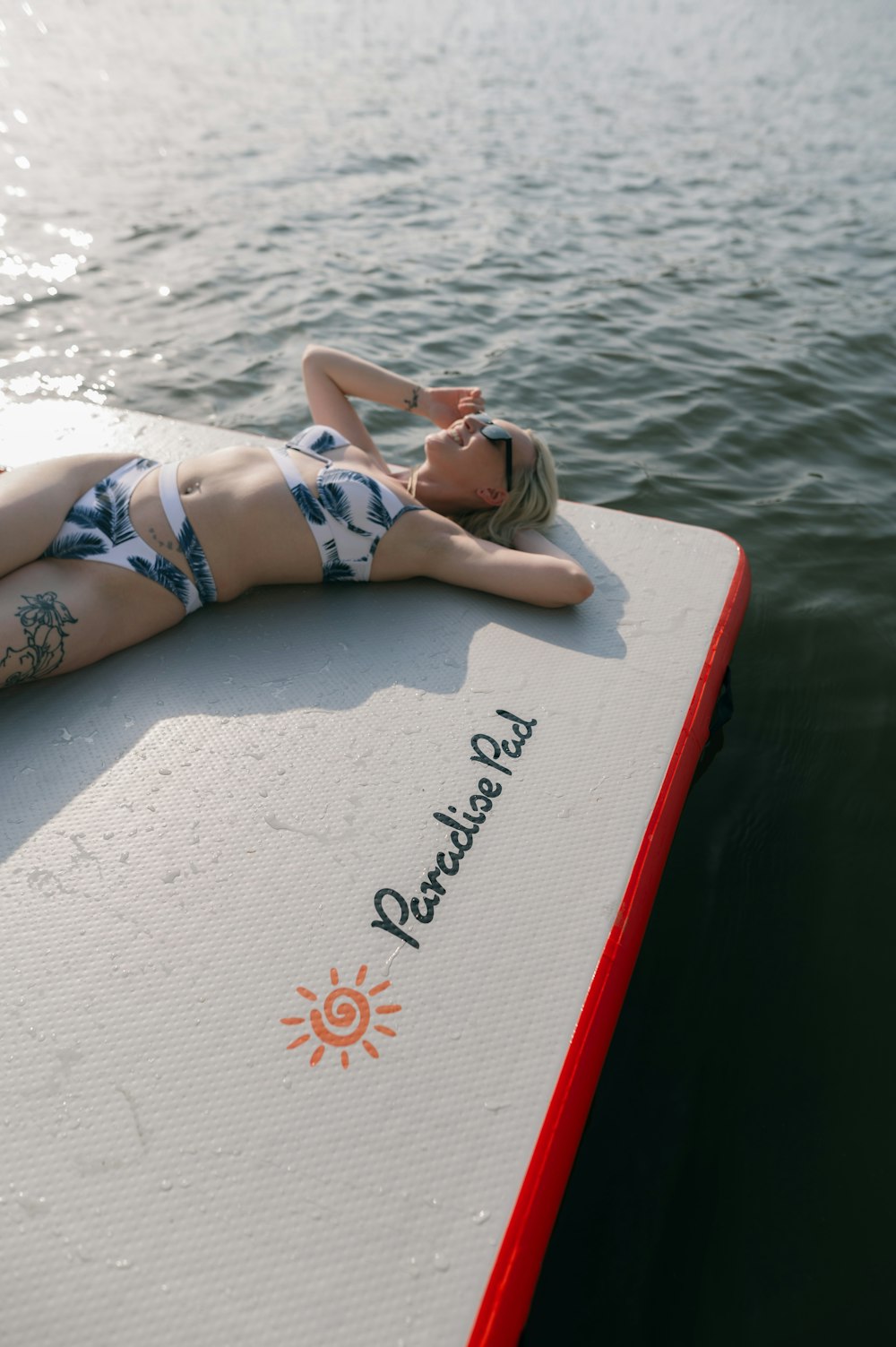 a woman laying on top of a surfboard in the water