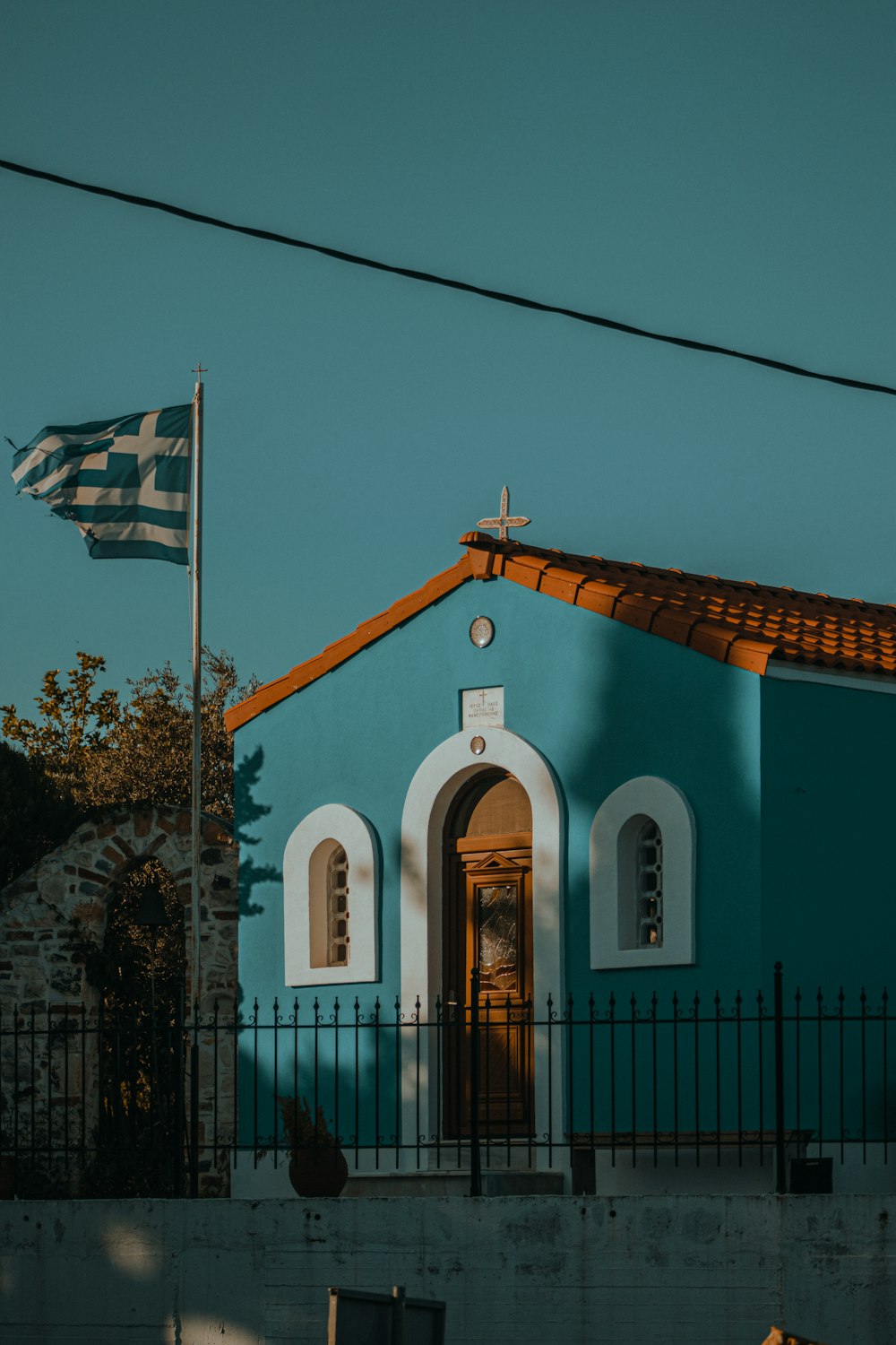 a blue church with a flag on top of it