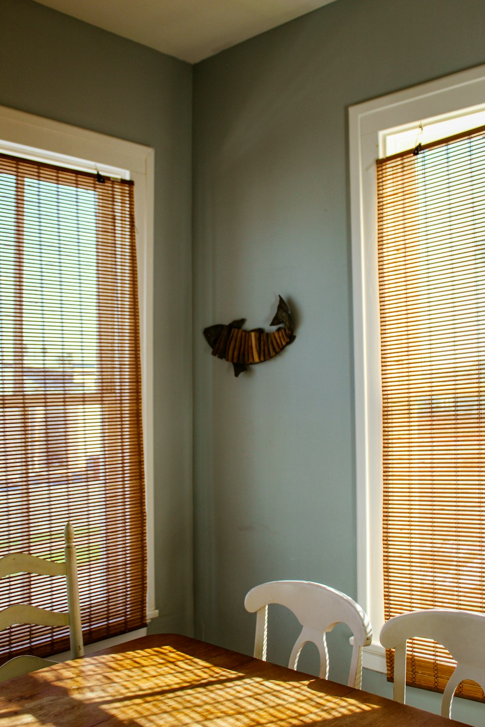 a dining room table with chairs and a clock on the wall