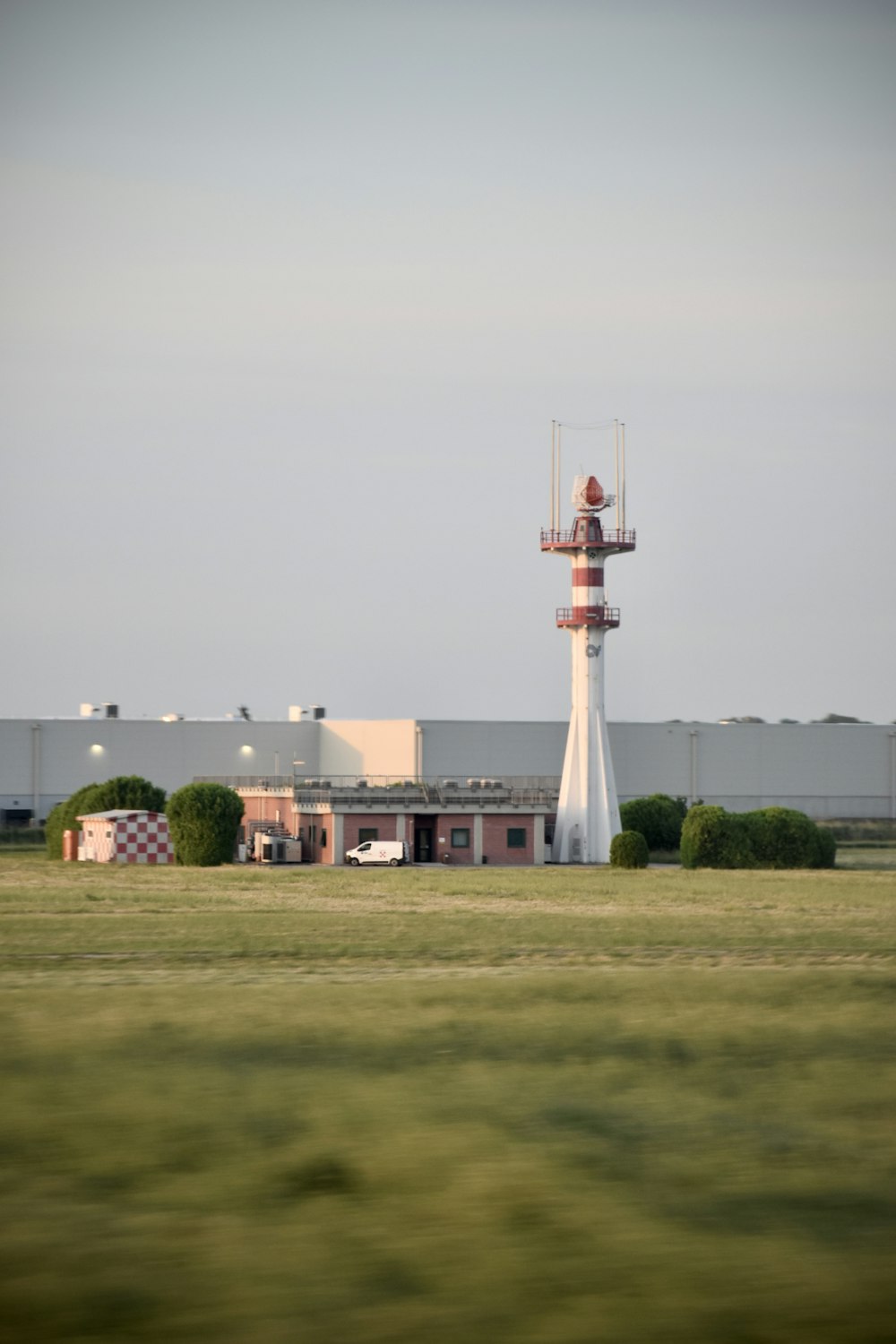 a tall white tower sitting in the middle of a field