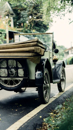 an old fashioned car is parked on the side of the road
