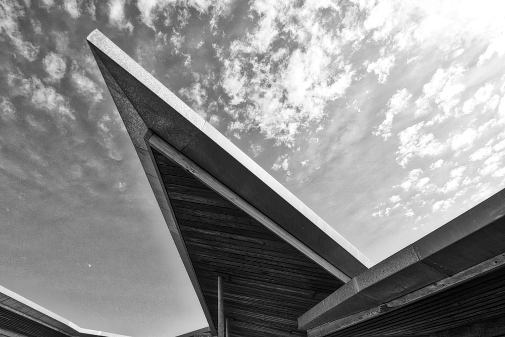 a black and white photo of a building under a cloudy sky