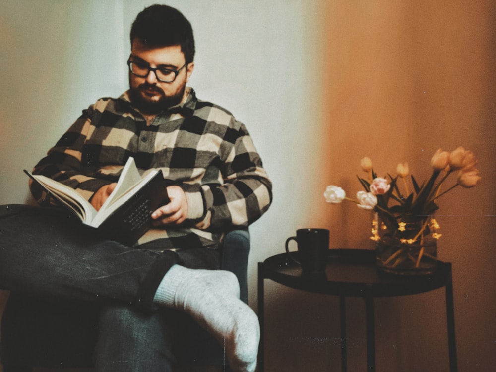 a man sitting in a chair reading a book