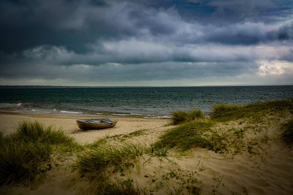 a boat sitting on top of a sandy beach