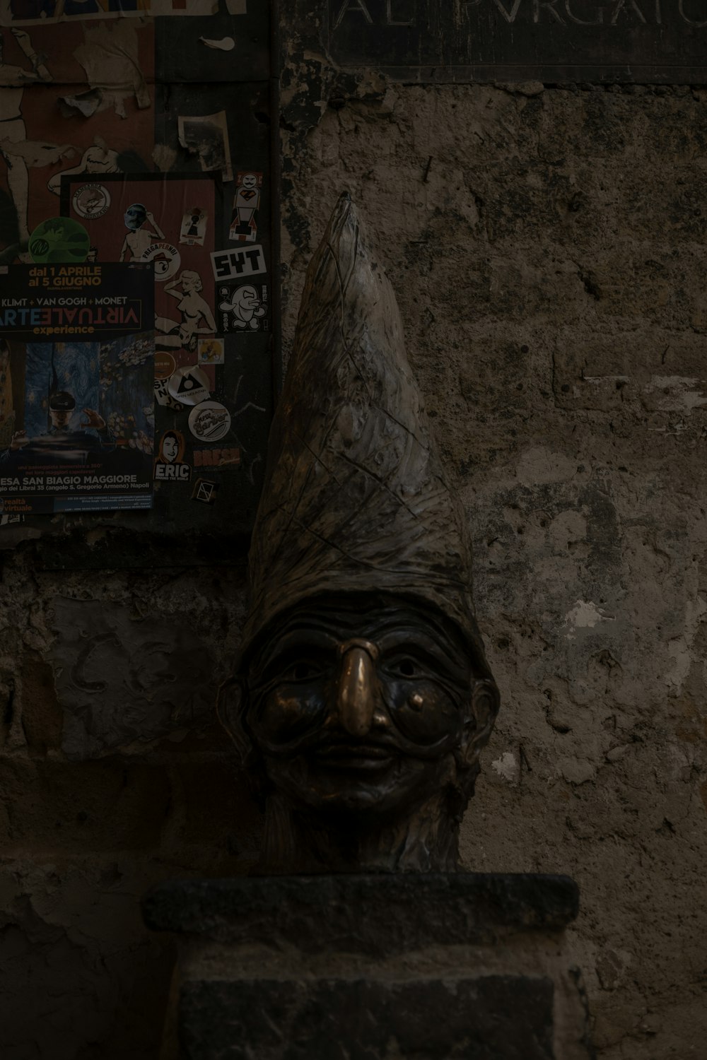 una estatua de la cabeza de un hombre frente a un letrero