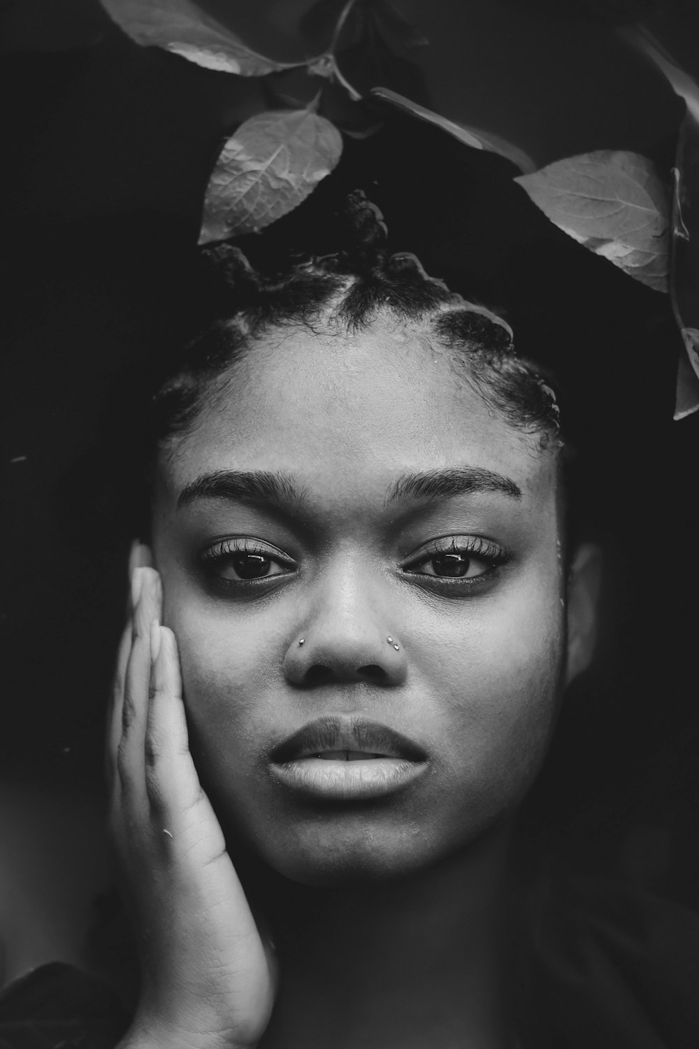 a black and white photo of a woman with her hands on her face