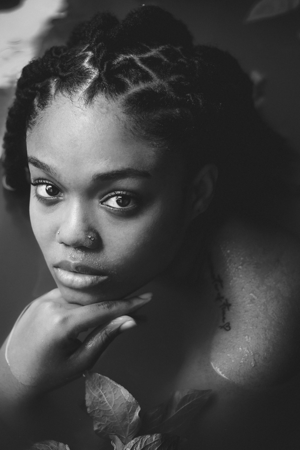 a black and white photo of a woman with braids