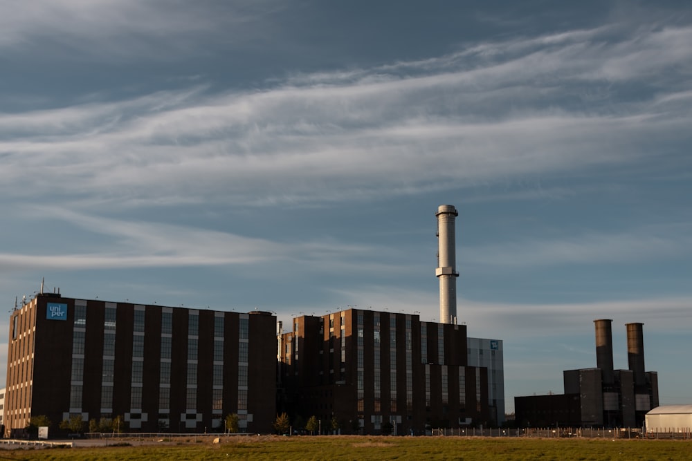 a factory building with smoke stacks in the background