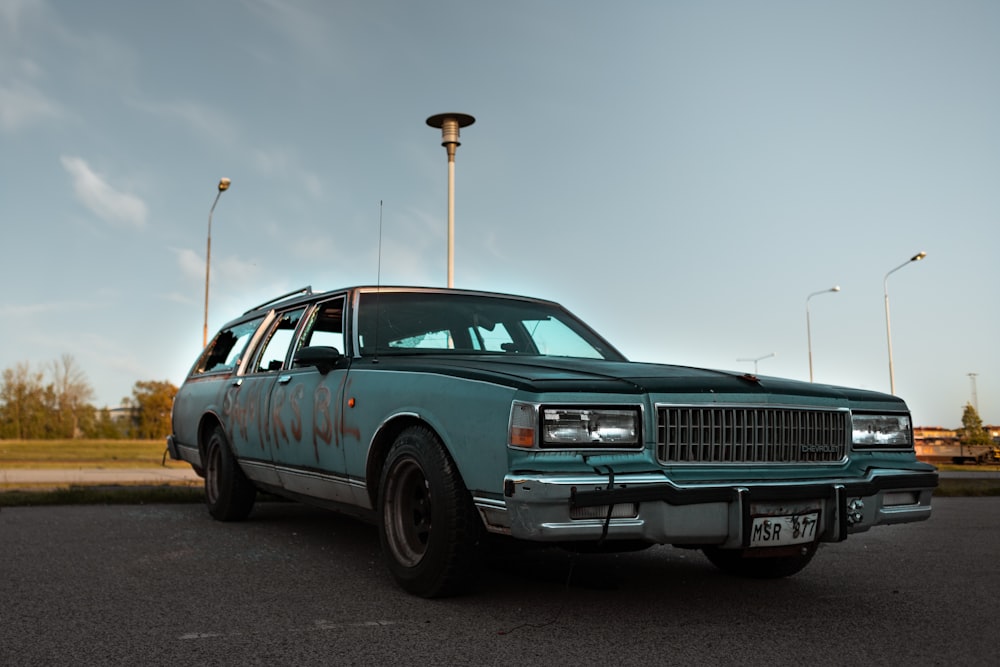 a blue station wagon parked in a parking lot