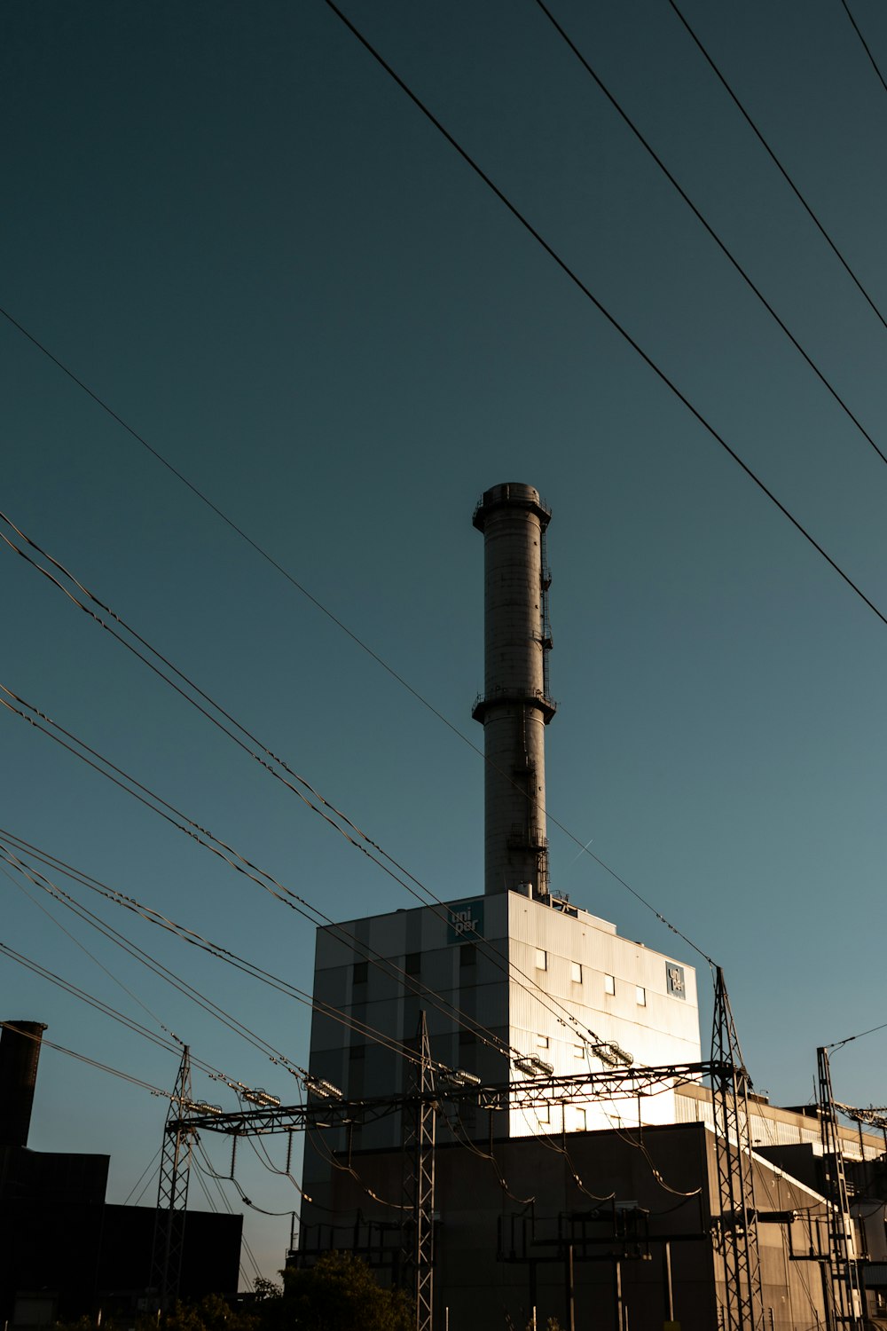 a factory building with power lines in the foreground