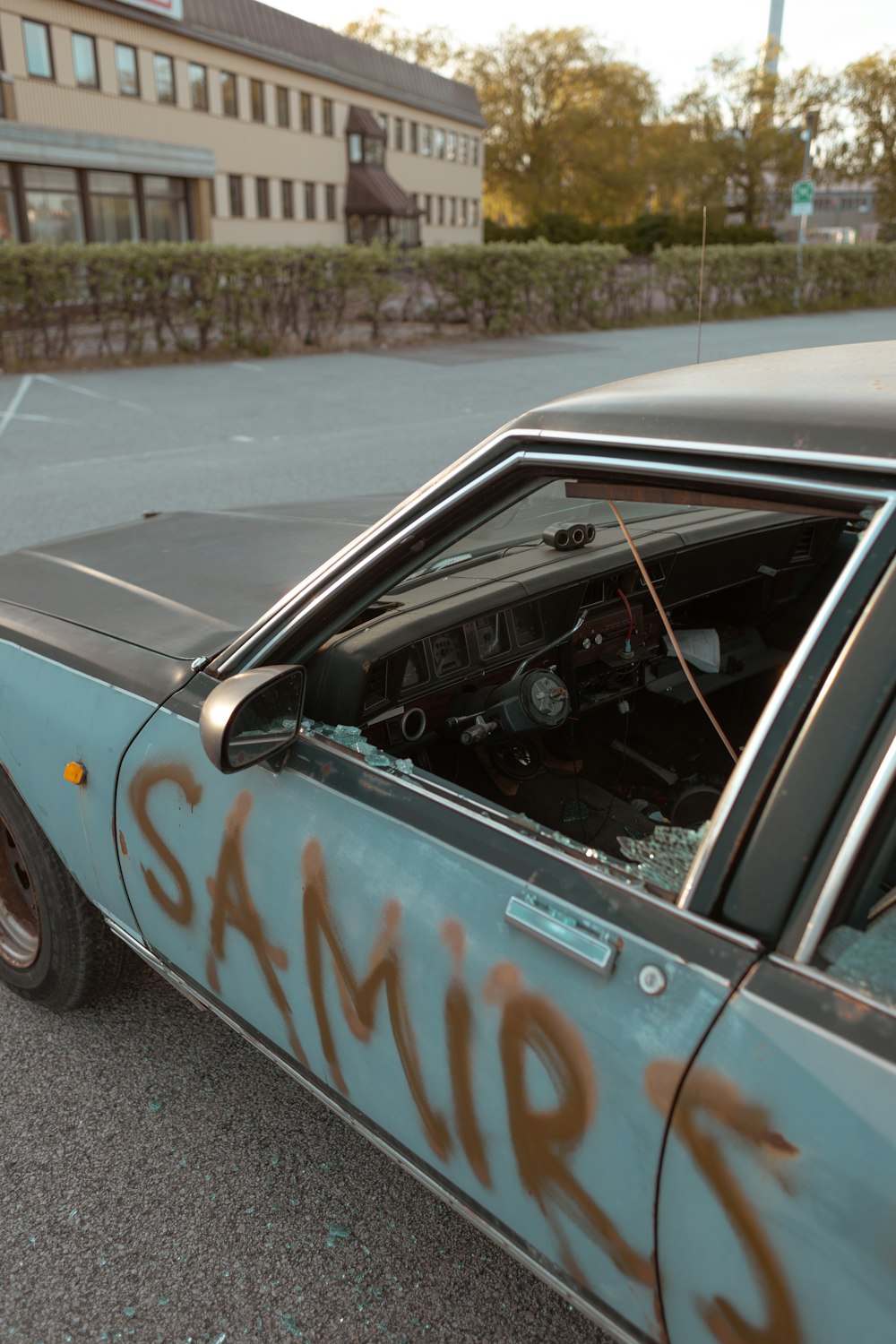 a car with graffiti on it parked on the side of the road