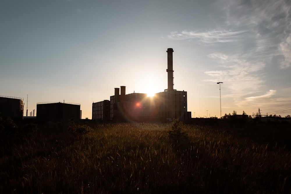 a factory with the sun setting behind it