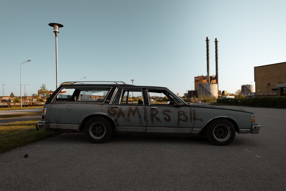 a car with graffiti on it parked in a parking lot