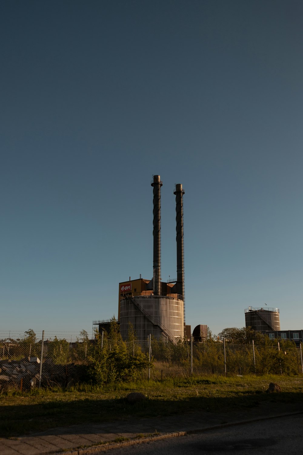 a factory with two smoke stacks in the background