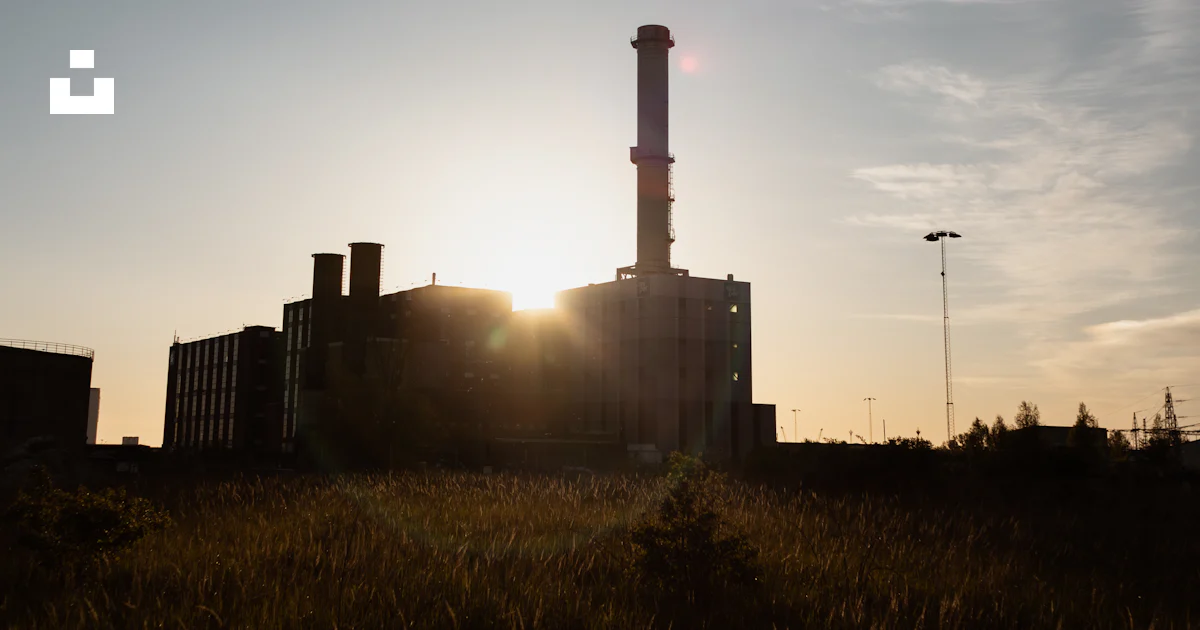 The sun is setting behind a factory building photo – Free Malmö Image ...