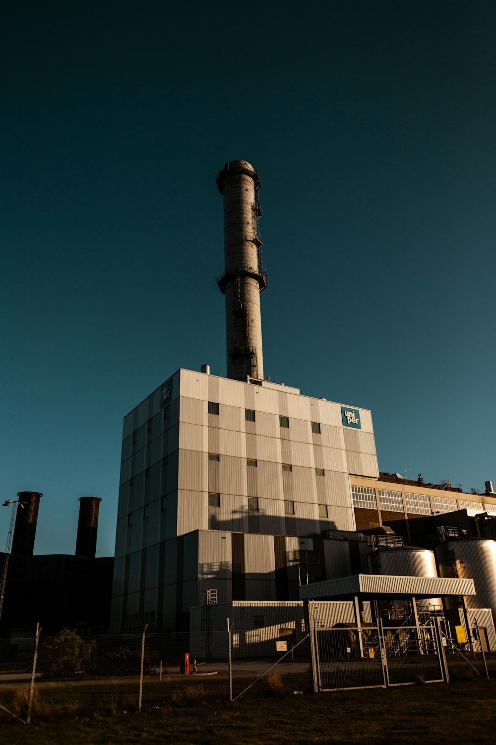 a factory building with a large smoke stack on top of it