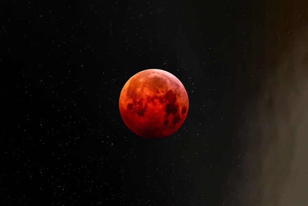 a red moon is seen in the night sky