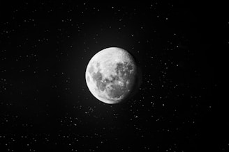 a full moon in the dark sky with stars