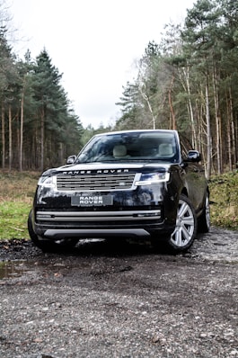 a black range rover parked on a gravel road