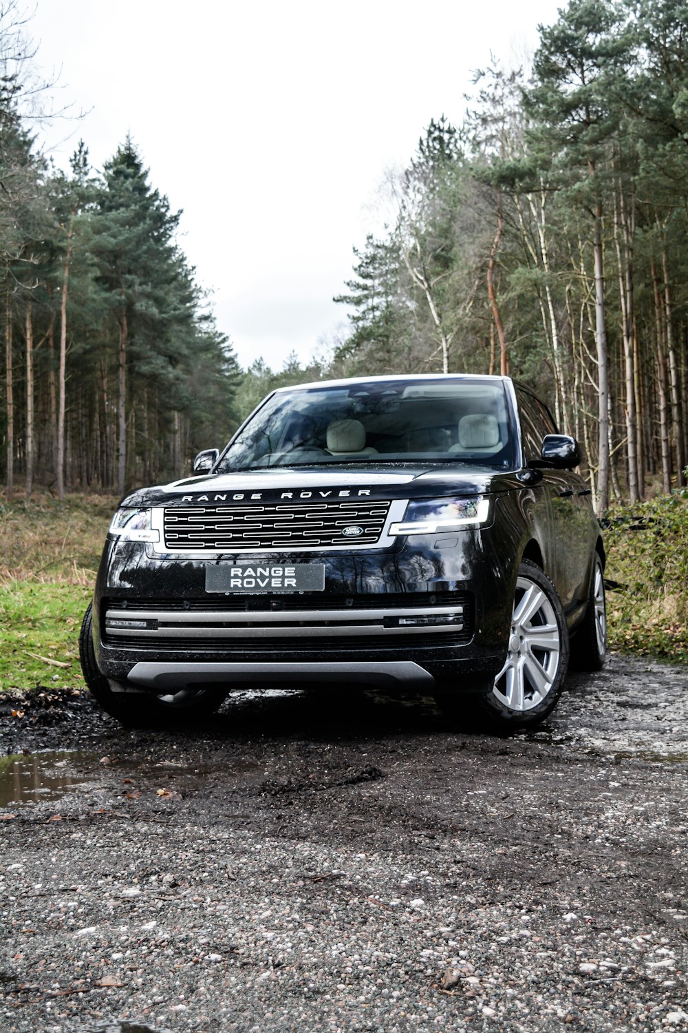 a black range rover parked on a gravel road