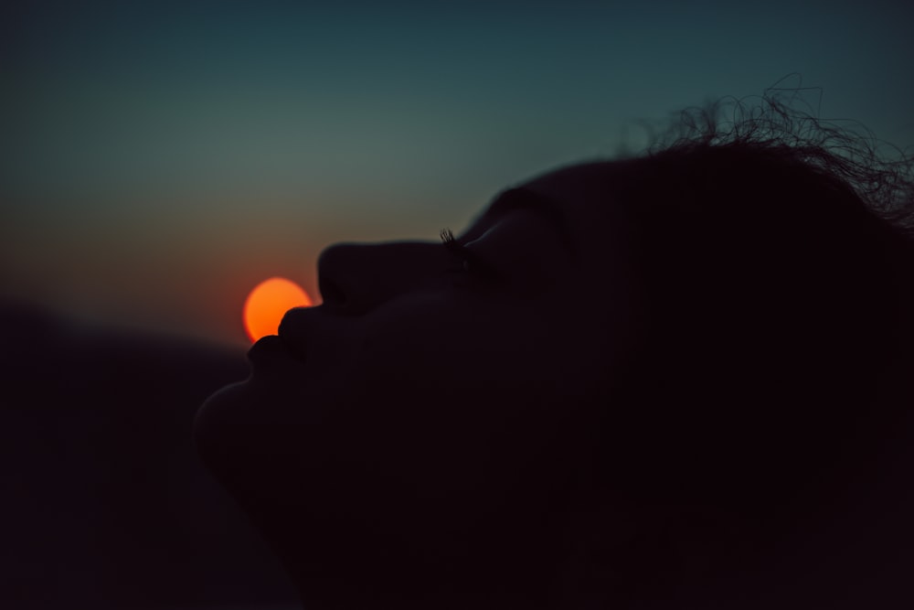 a woman looking up at the sun with her eyes closed