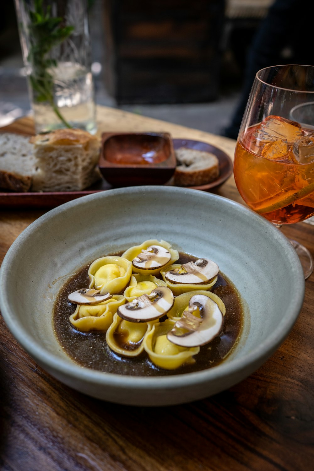 a bowl of food and a glass of wine on a table