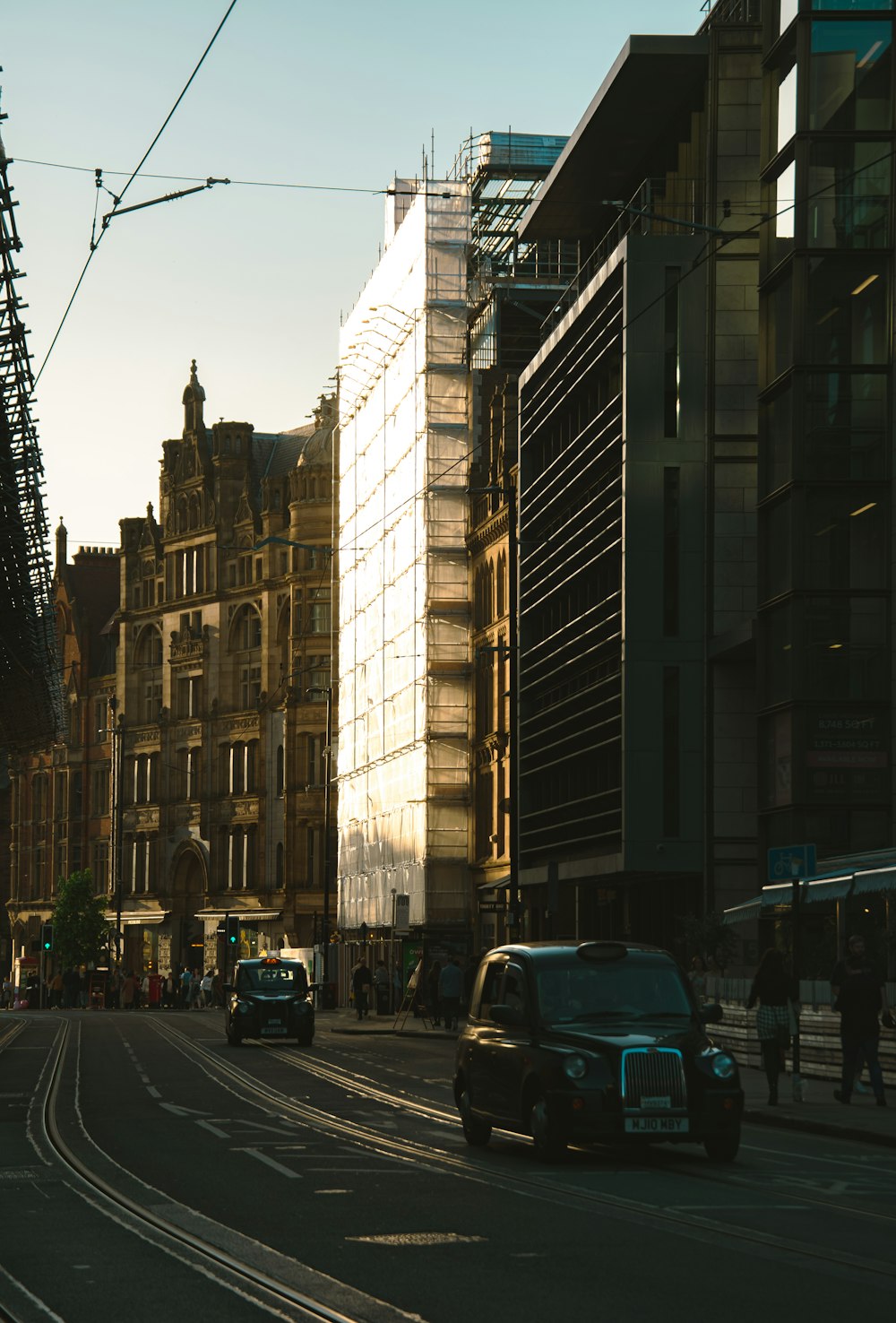 a car driving down a street next to tall buildings