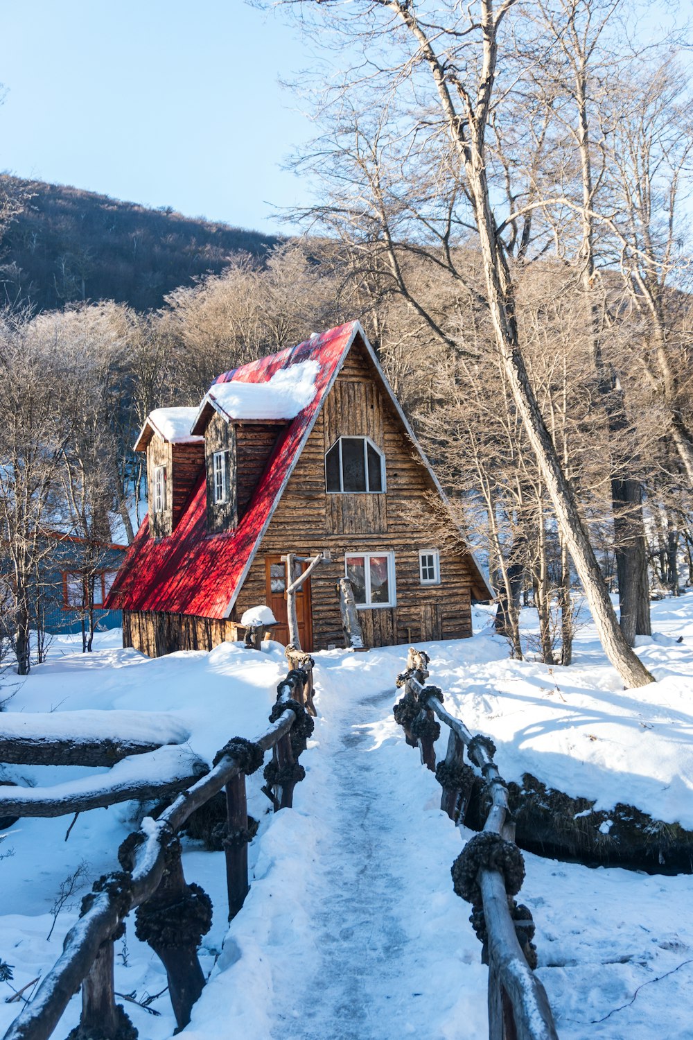 a wooden cabin with a red tarp on the roof