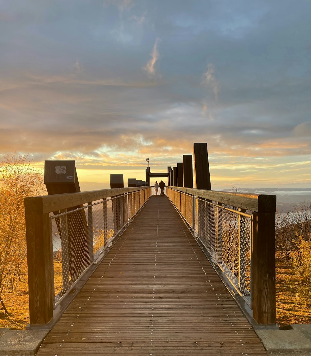 a wooden bridge with a bench on the side of it