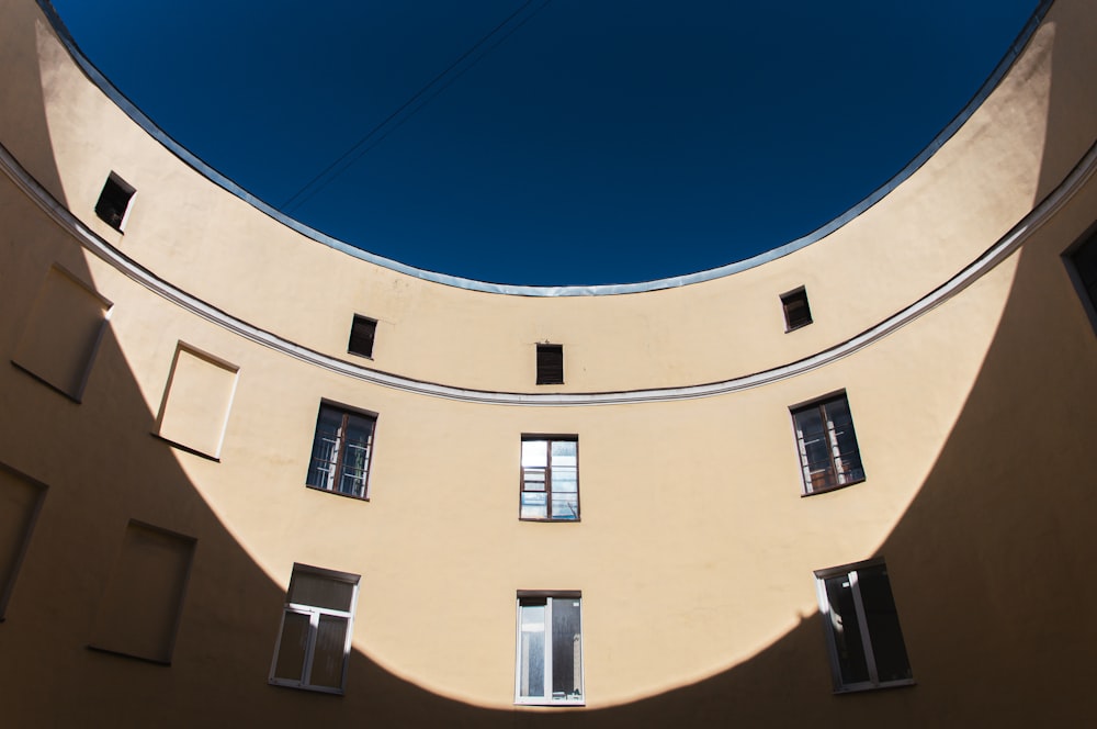 a round building with windows and a sky background