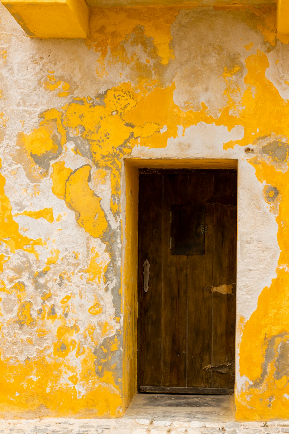 a yellow and white building with a wooden door