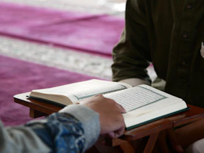 a person sitting at a table with an open book