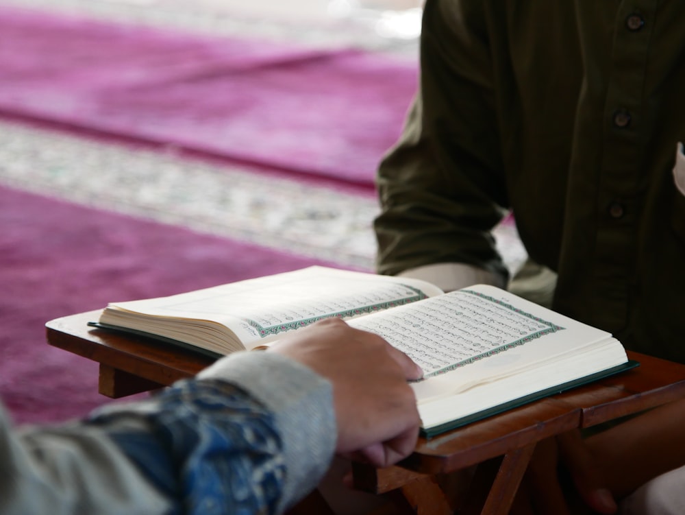 a person sitting at a table with an open book