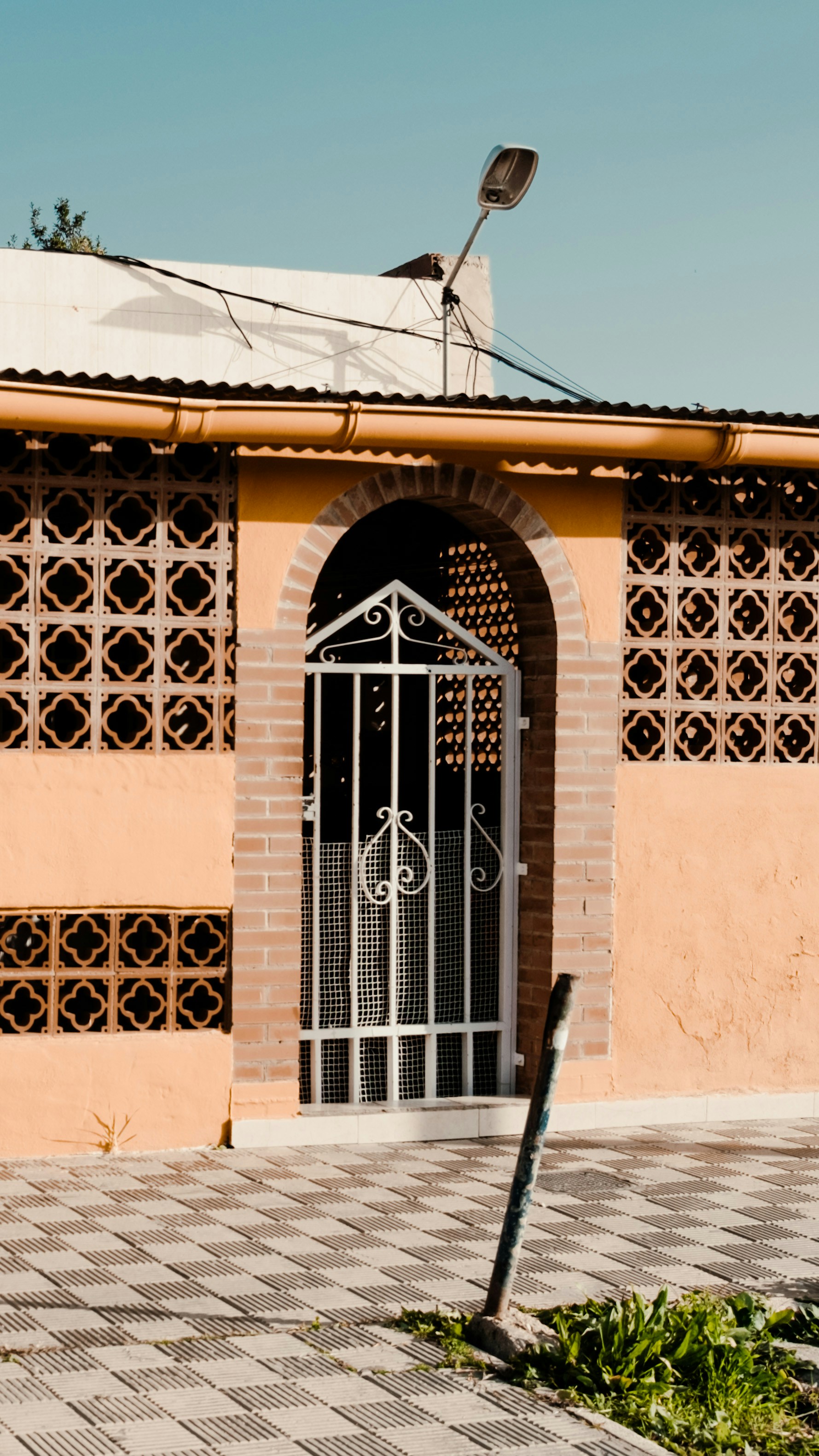 a brick building with a gate and a street sign