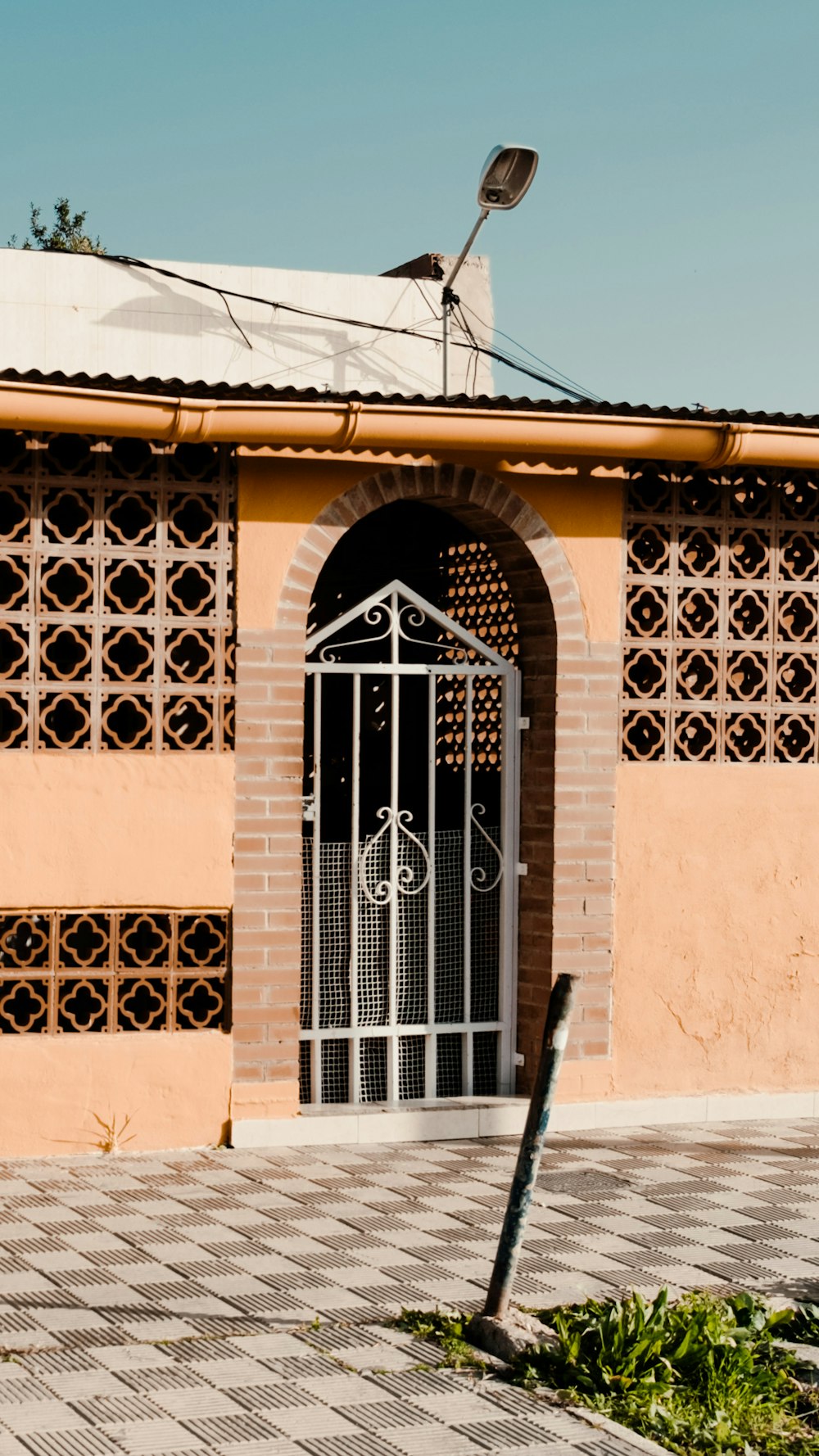 a brick building with a gate and a street sign