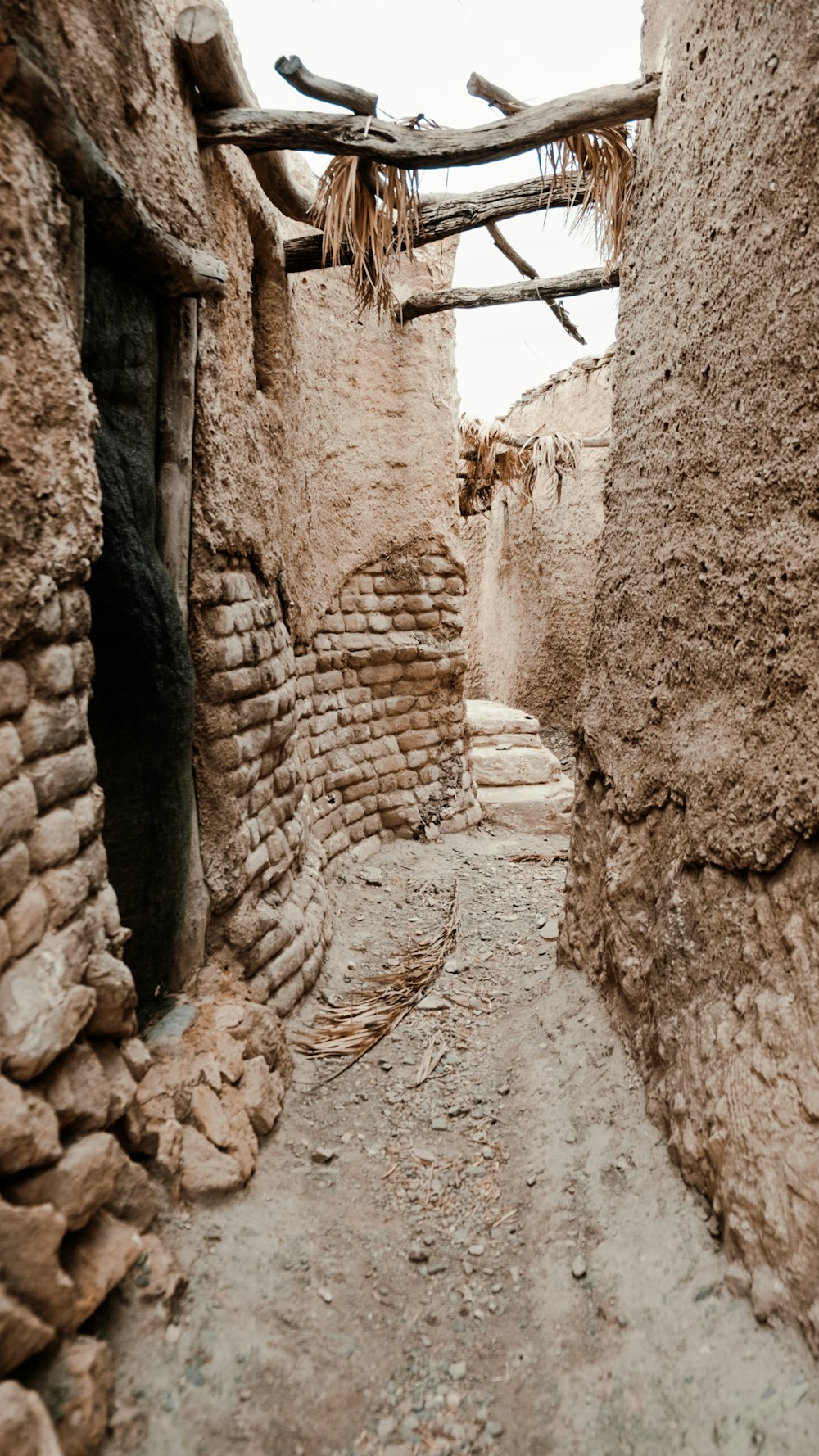 a narrow alley with stone walls and a wooden roof