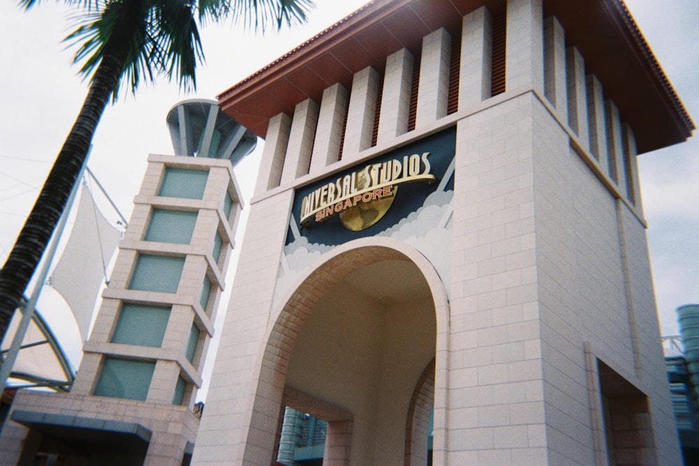 a tall white clock tower with a sign on it's side