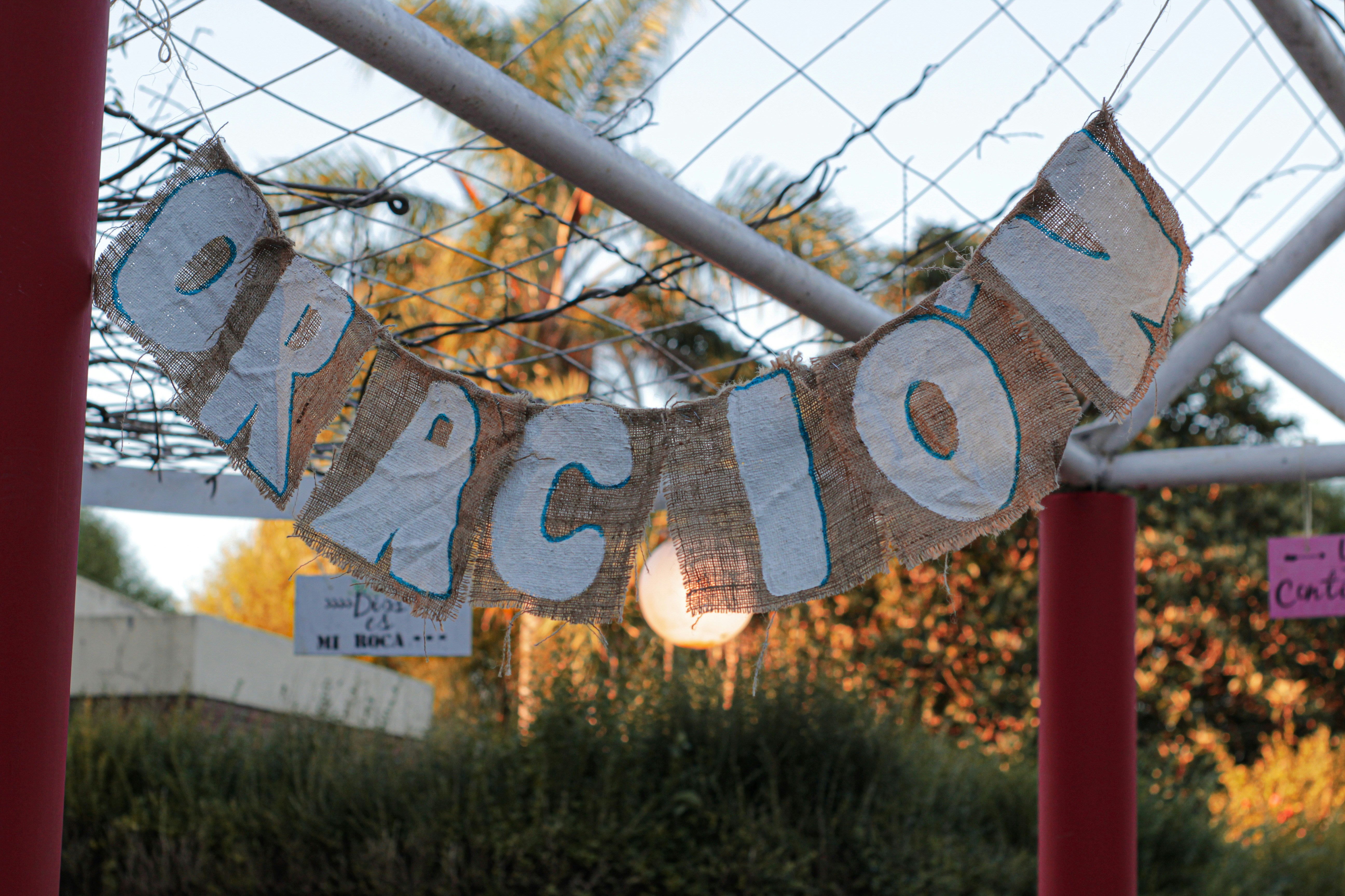 Un cartello che dice benvenuto appeso a una recinzione