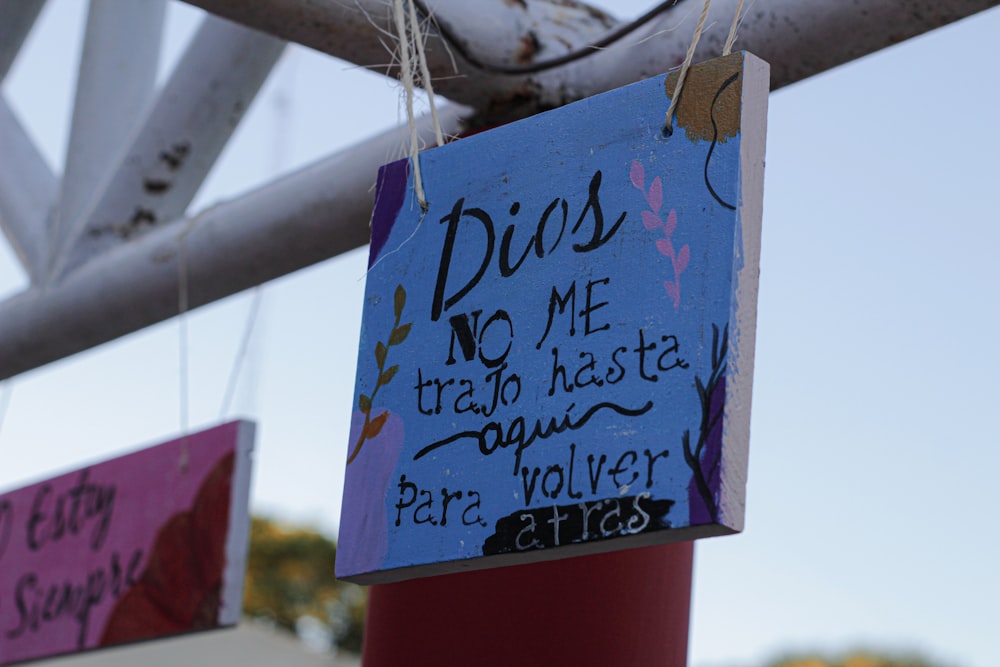 a blue sign hanging from a metal pole