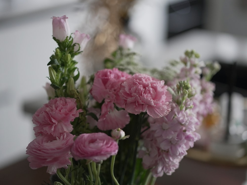 a vase filled with pink flowers on top of a table