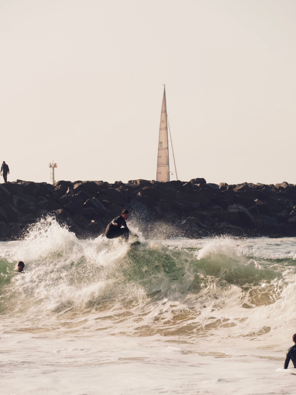 a man riding a wave on top of a surfboard