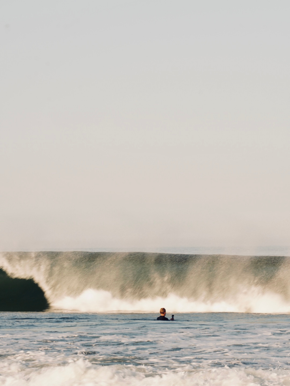 a man riding a wave on top of a surfboard