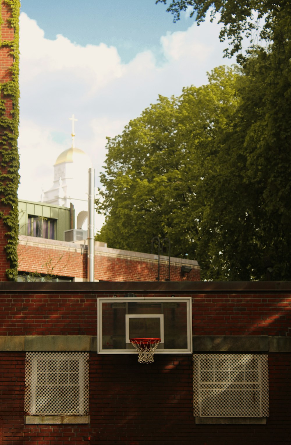 a basketball hoop hanging from the side of a brick building