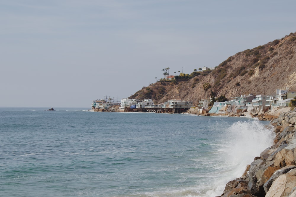 a view of a beach with houses on a hill in the background