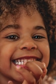 A close-up of a child smiling in a stylish outfit.