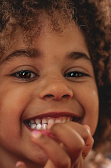A close-up of a child’s joyful face as they receive a new toy from a caring volunteer.
