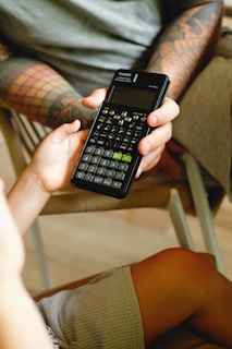 a person sitting in a chair holding a cell phone