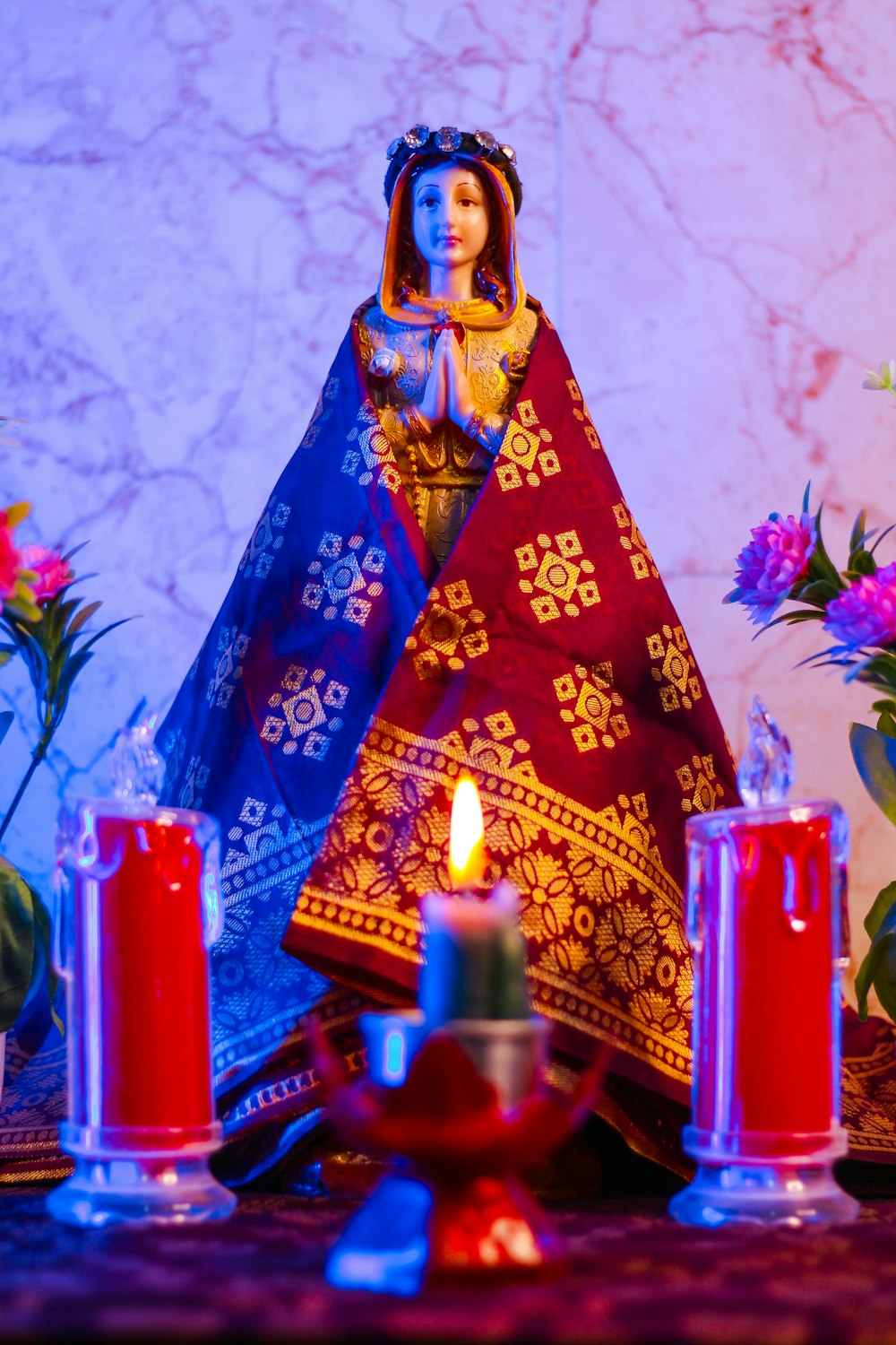 a statue of a virgin mary surrounded by candles